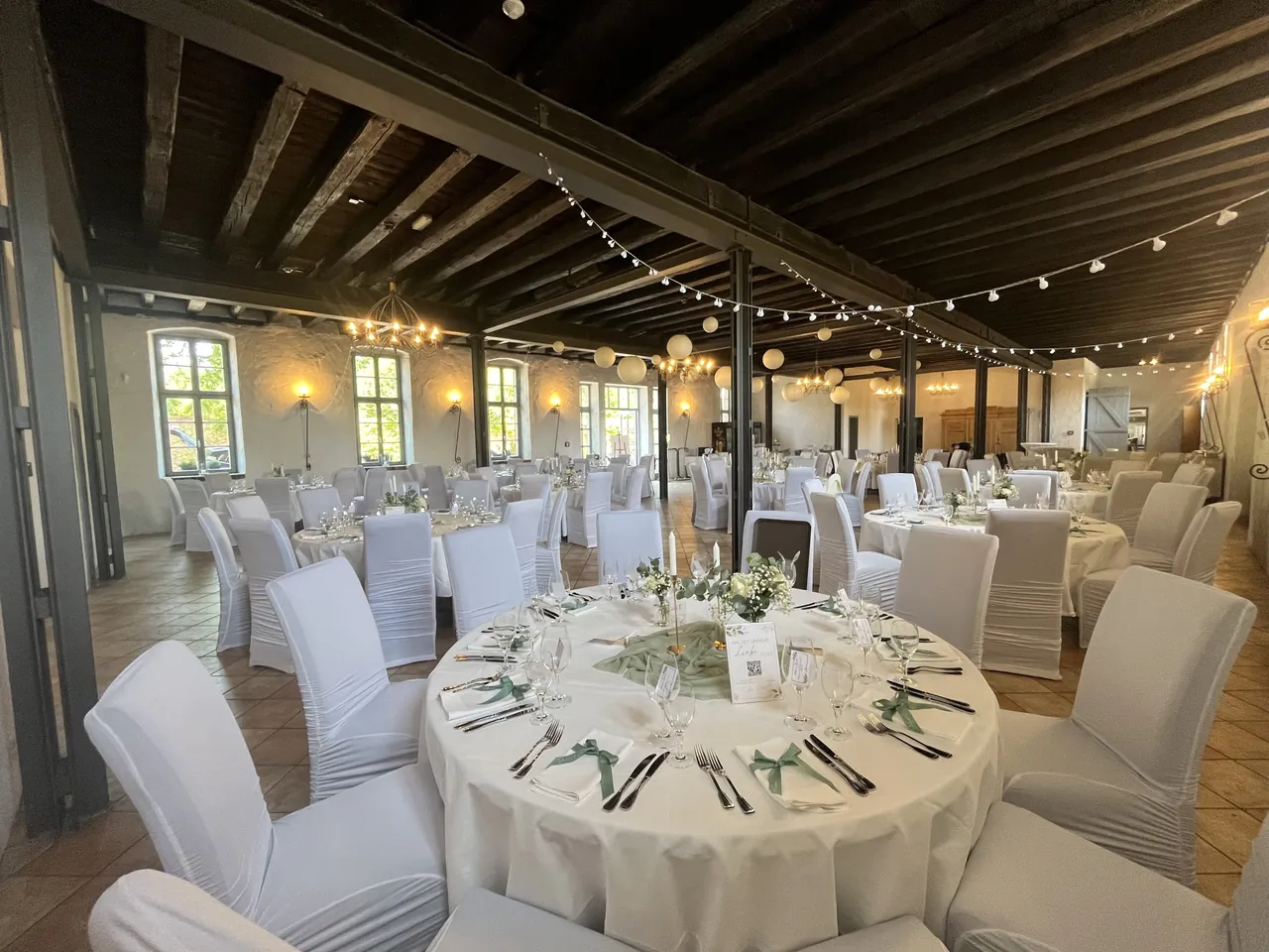 Flick Falkenberg: Festsaal mit runden Tischen und Lichterketten