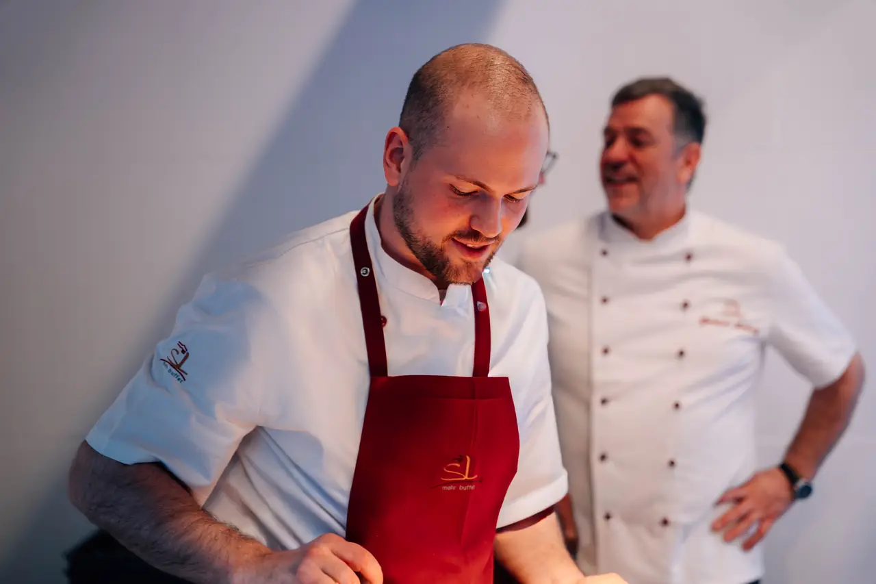 Zwei Köche von SL mehr buffet lachen gemeinsam bei der Arbeit