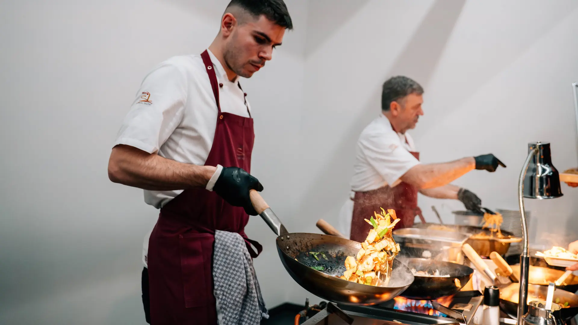 Zwei Köche von SL mehr buffet arbeiten an Pfannen-Stationen